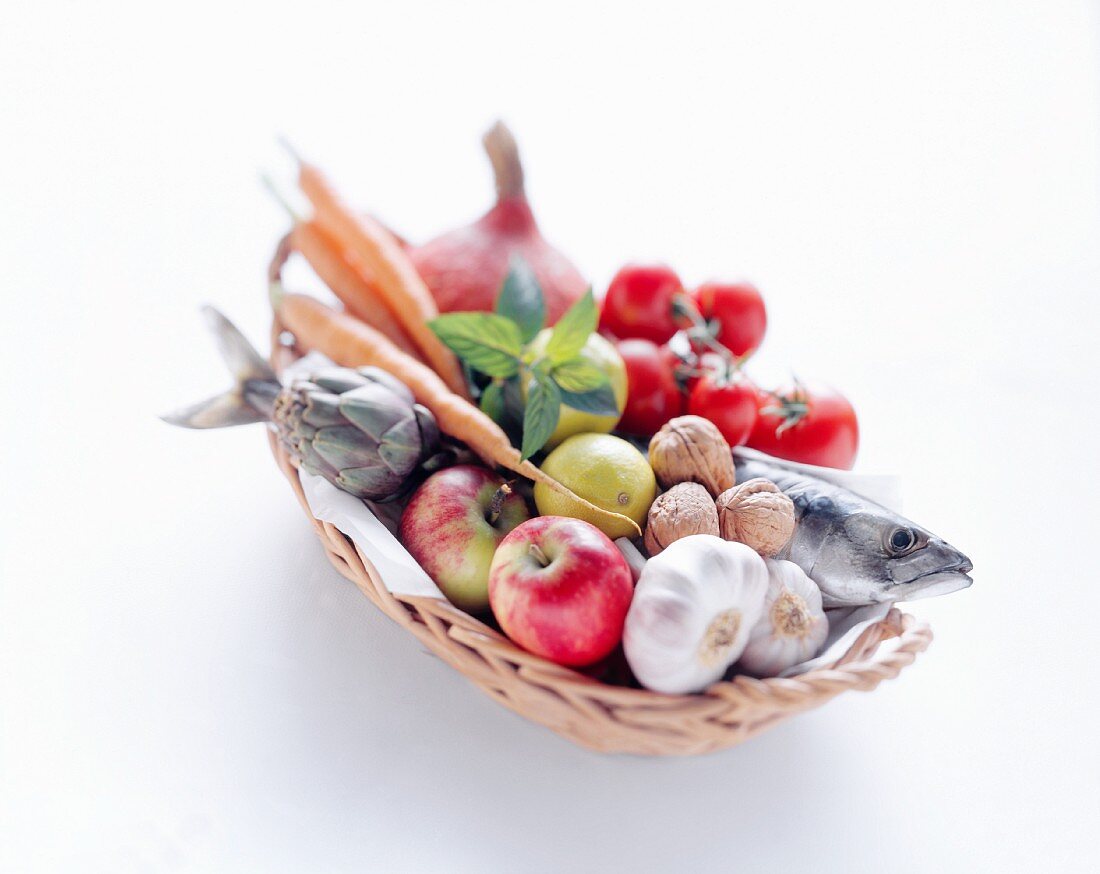 Ein Korb mit Makrele, Obst, Gemüsen und Nüssen