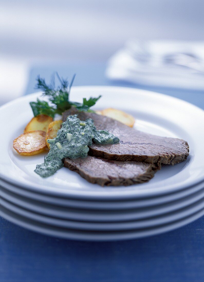 Beef with herb sauce and roast potatoes