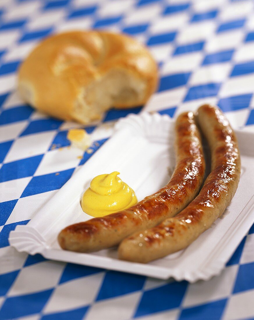 Sausages with mustard on paper plate (Bavaria, Germany)
