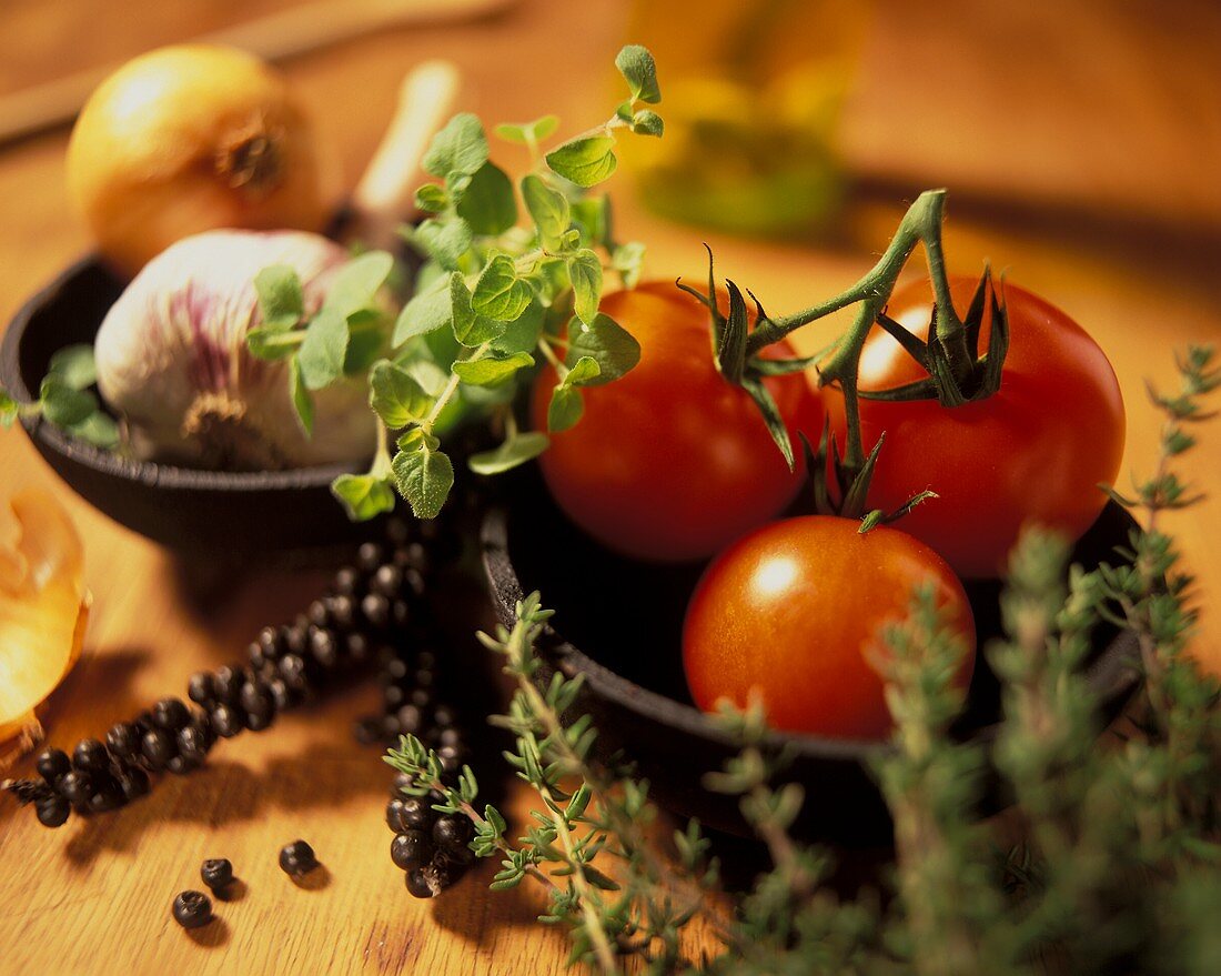 Stillleben mit Tomaten, Kräutern, Knoblauch und Zwiebel