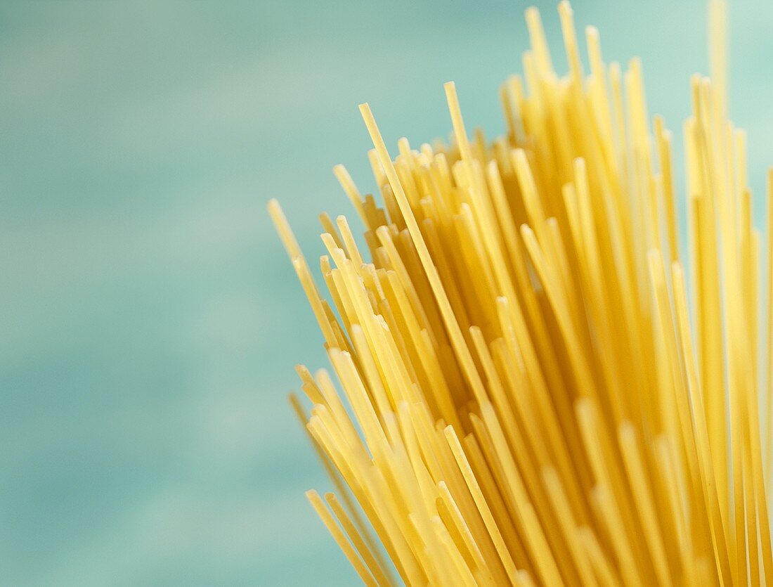 Spaghetti against turquoise background