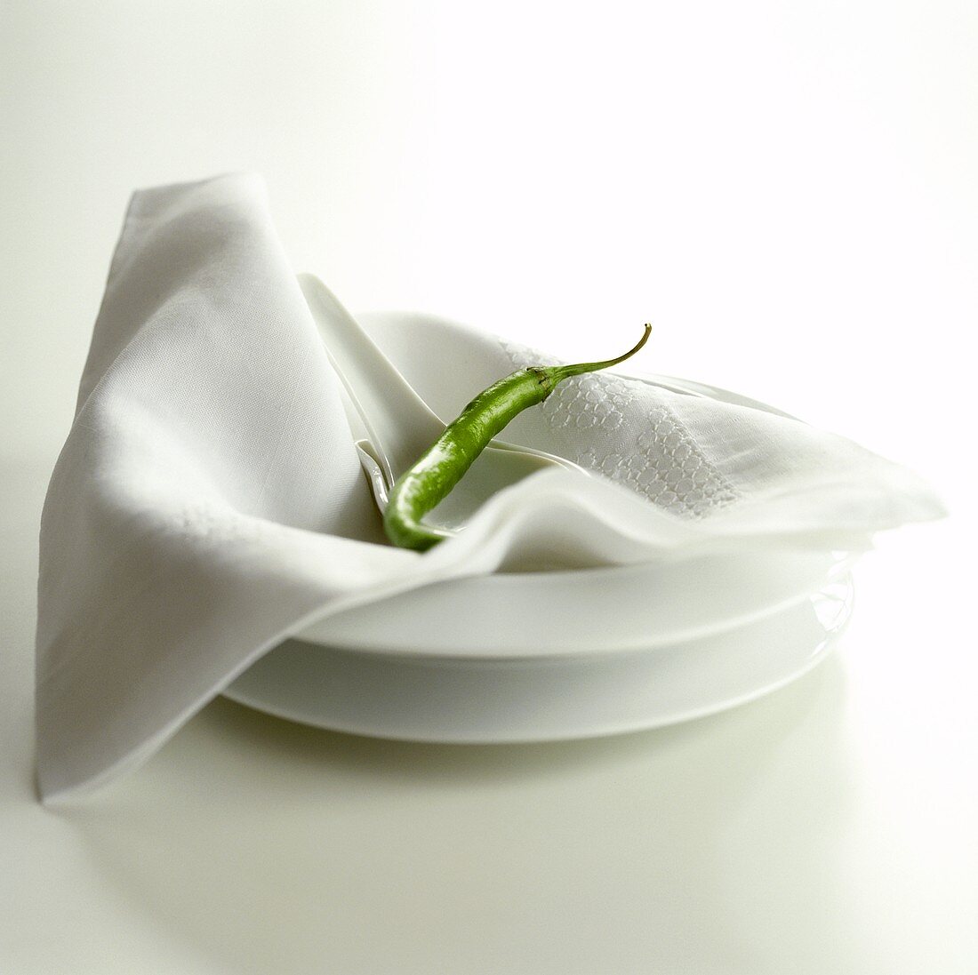A green chili pepper on napkin and plate