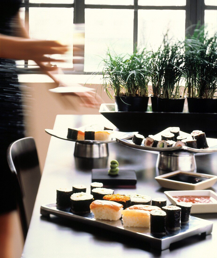 Woman at a buffet with various sushi