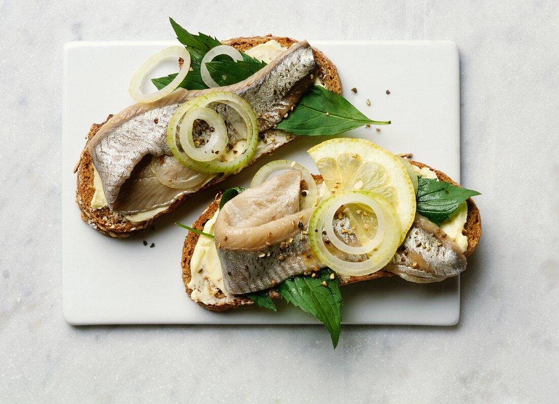 Open sandwiches with marinated herrings, mint and lemon