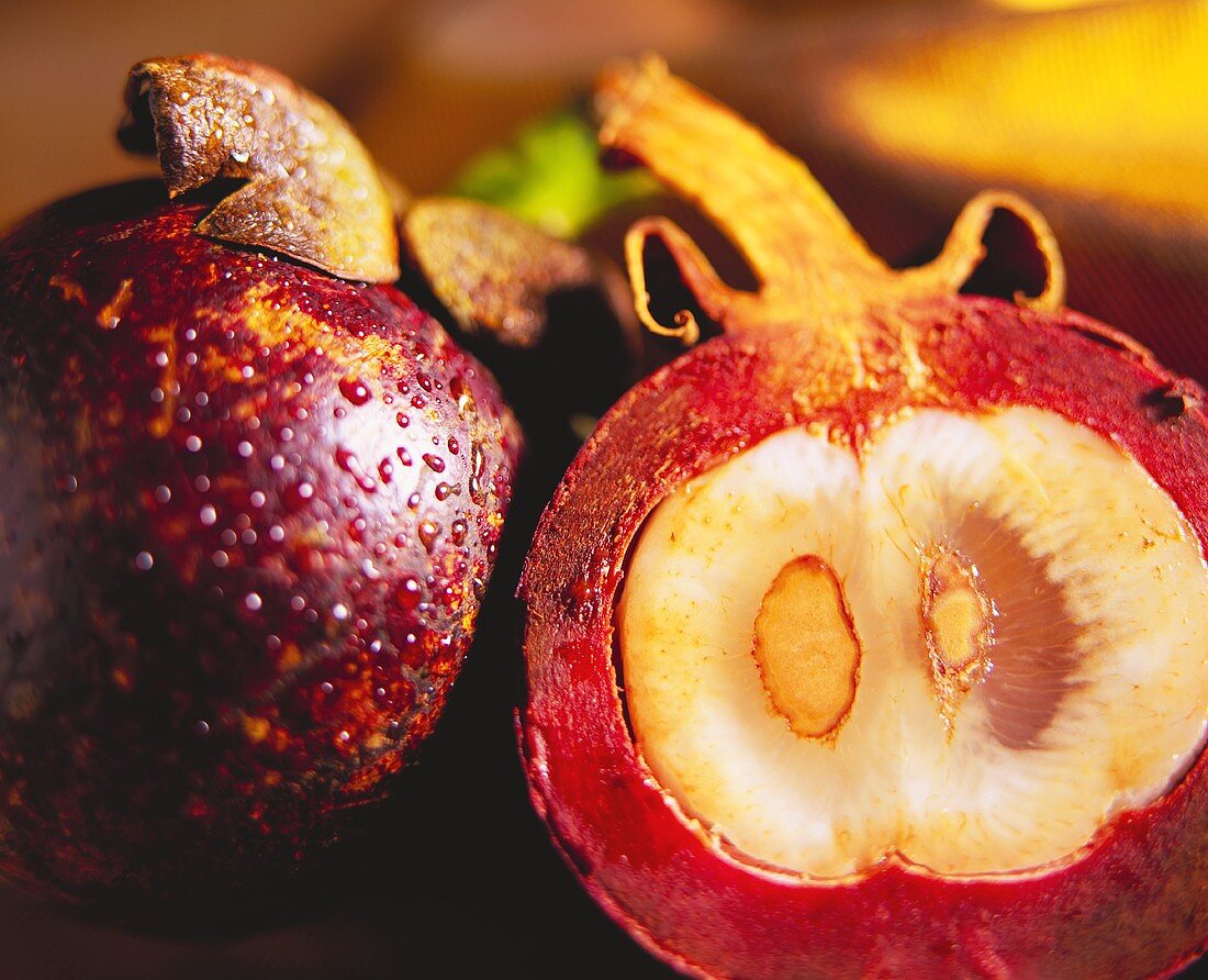 A whole and a halved mangosteen