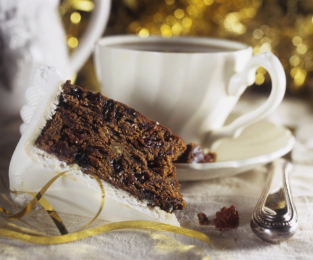 A piece of Christmas cake with a cup of coffee