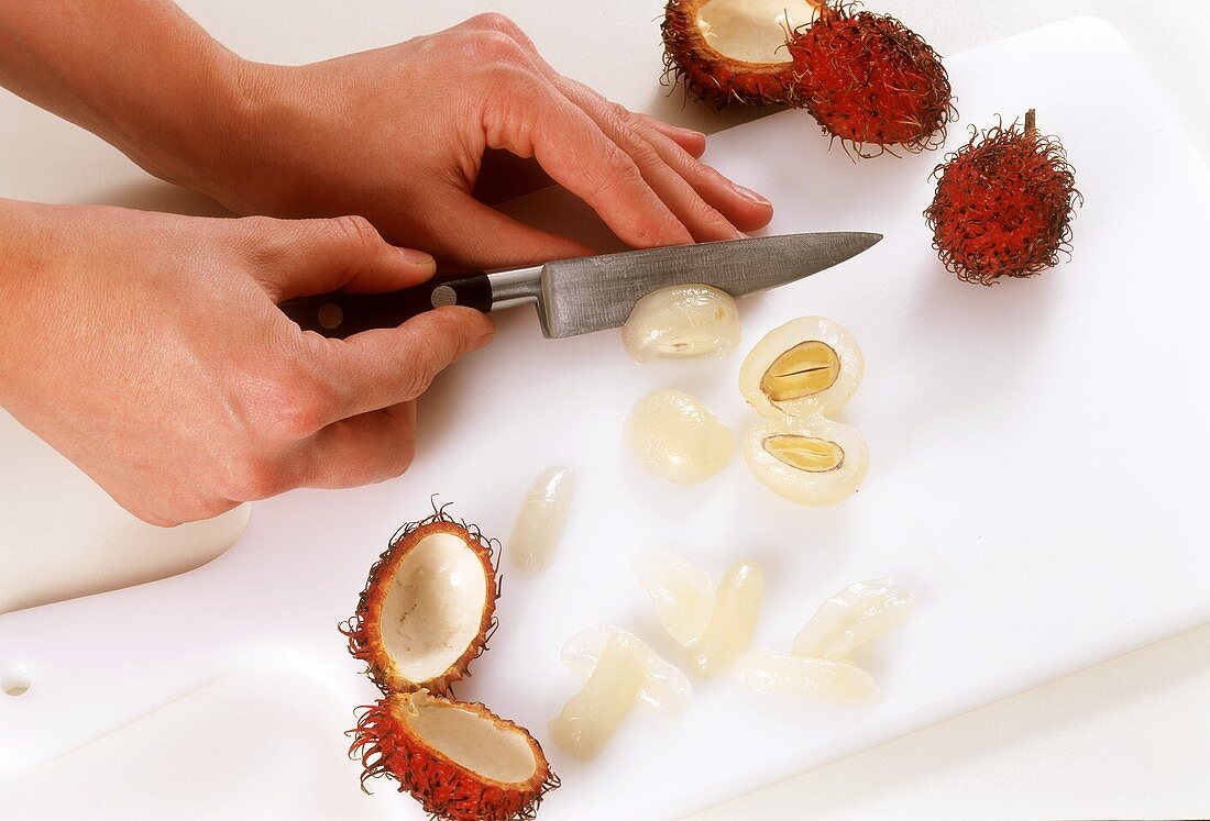 Fruchtfleisch einer Rambutan vom Kern lösen