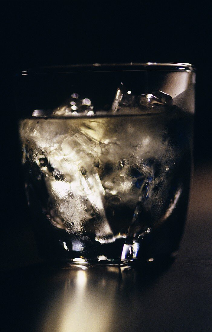 A glass of vodka and tonic with ice cubes