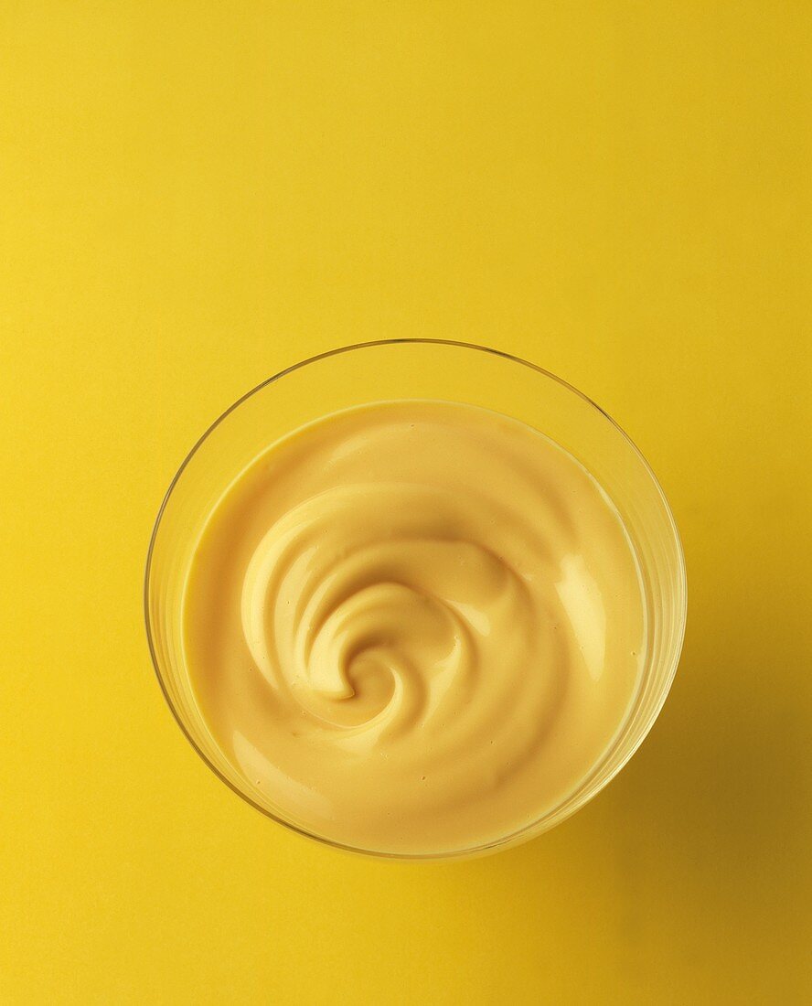 Vanilla mousse in a glass with yellow backdrop
