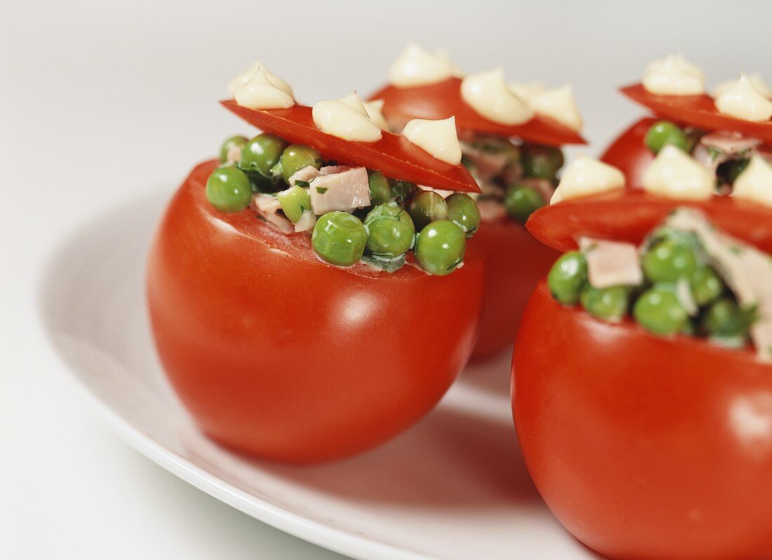 Stuffed tomatoes with cooked ham, peas and onions