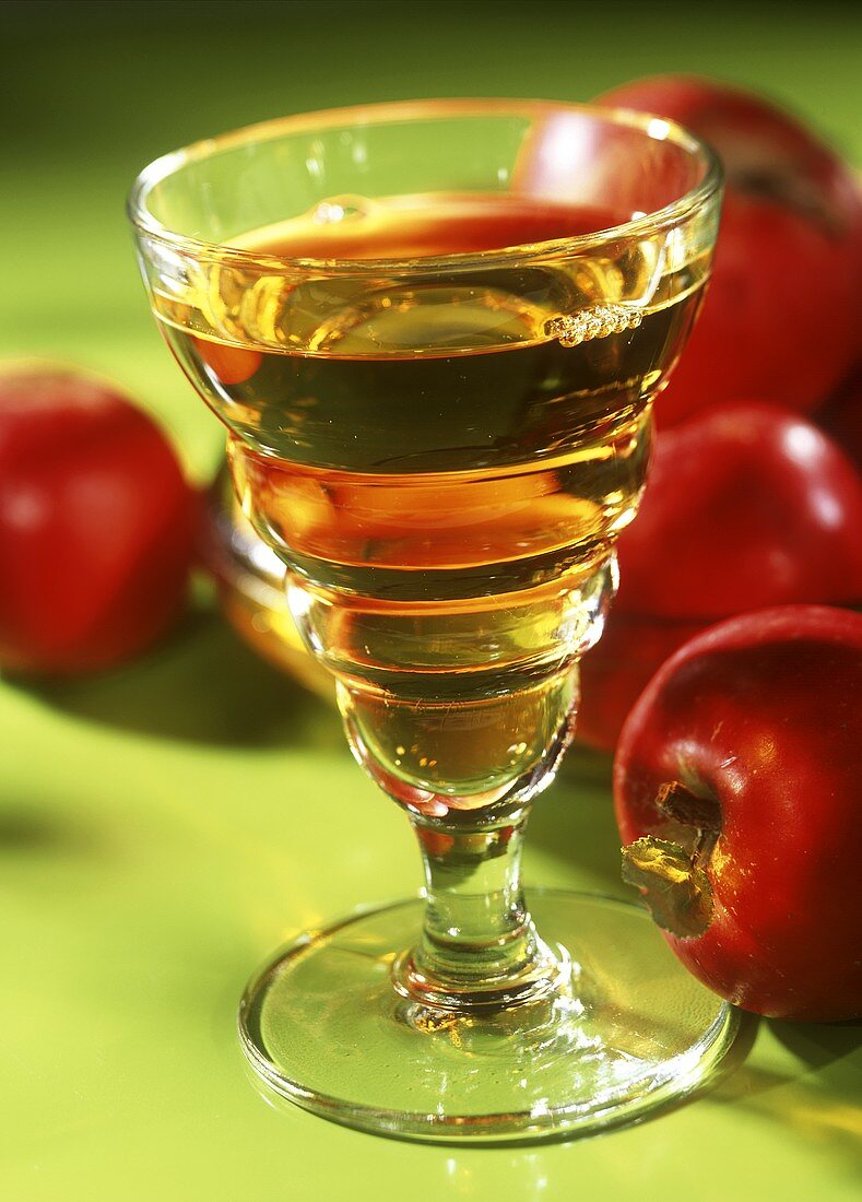 A glass of apple juice and red apples