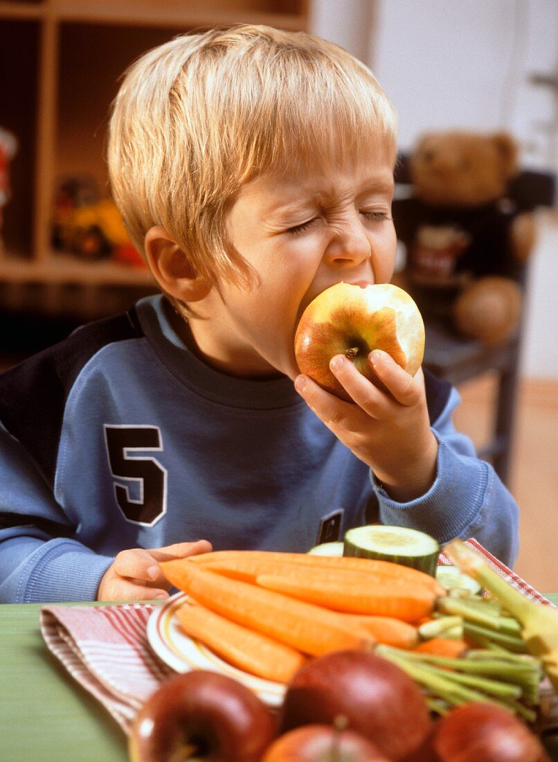 Small boy eating an apple