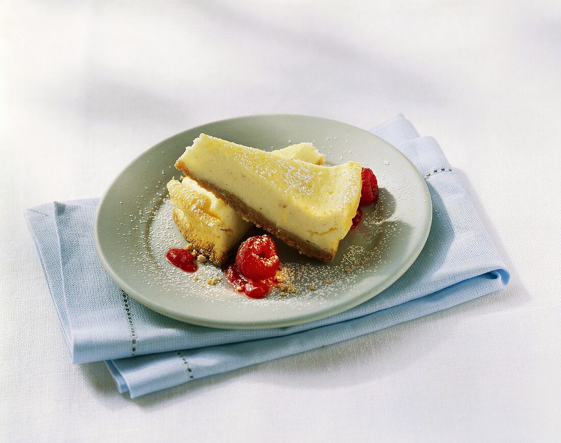 Zwei Stück Cheesecake mit Himbeeren