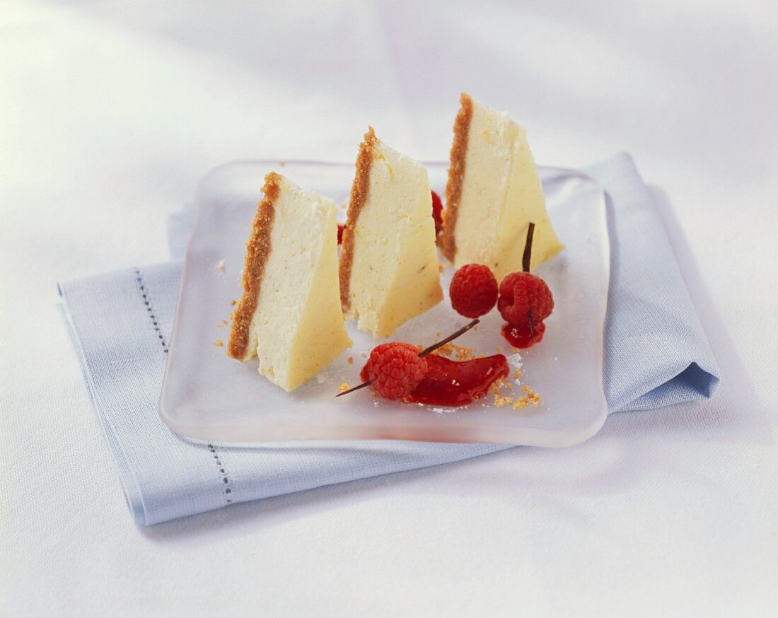 Drei Stück Cheesecake mit Himbeeren und Vanilleschoten