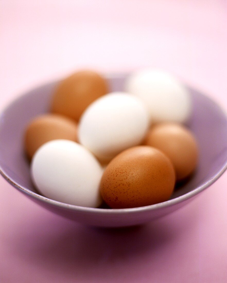 Brown and white eggs in a bowl