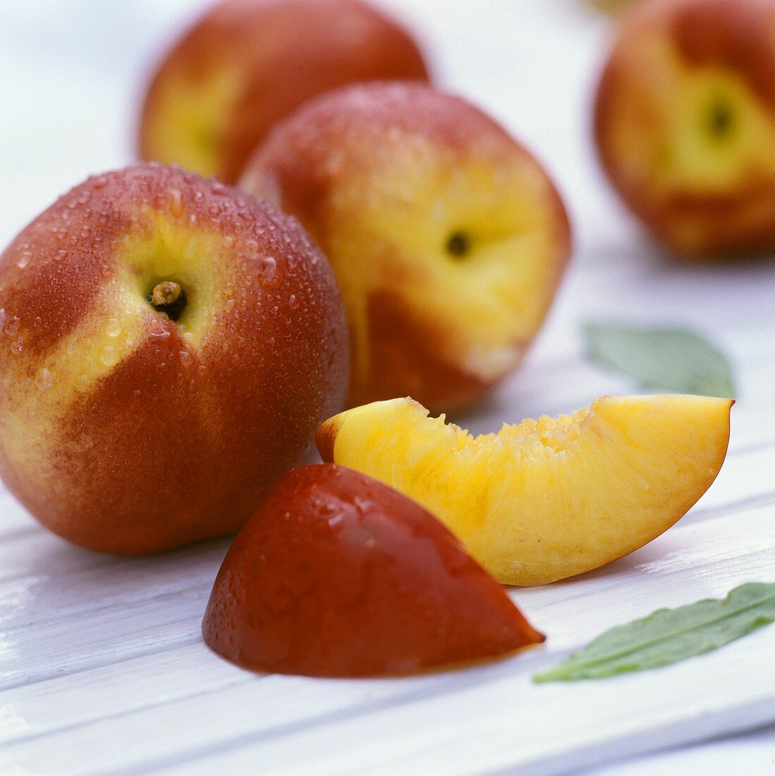 Nectarine wedges in front of whole nectarines