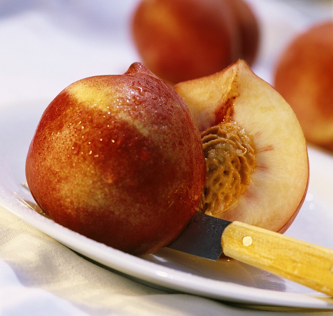 Halved nectarine with knife