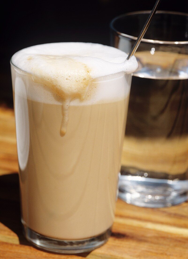 Latte macchiato, a glass of water behind