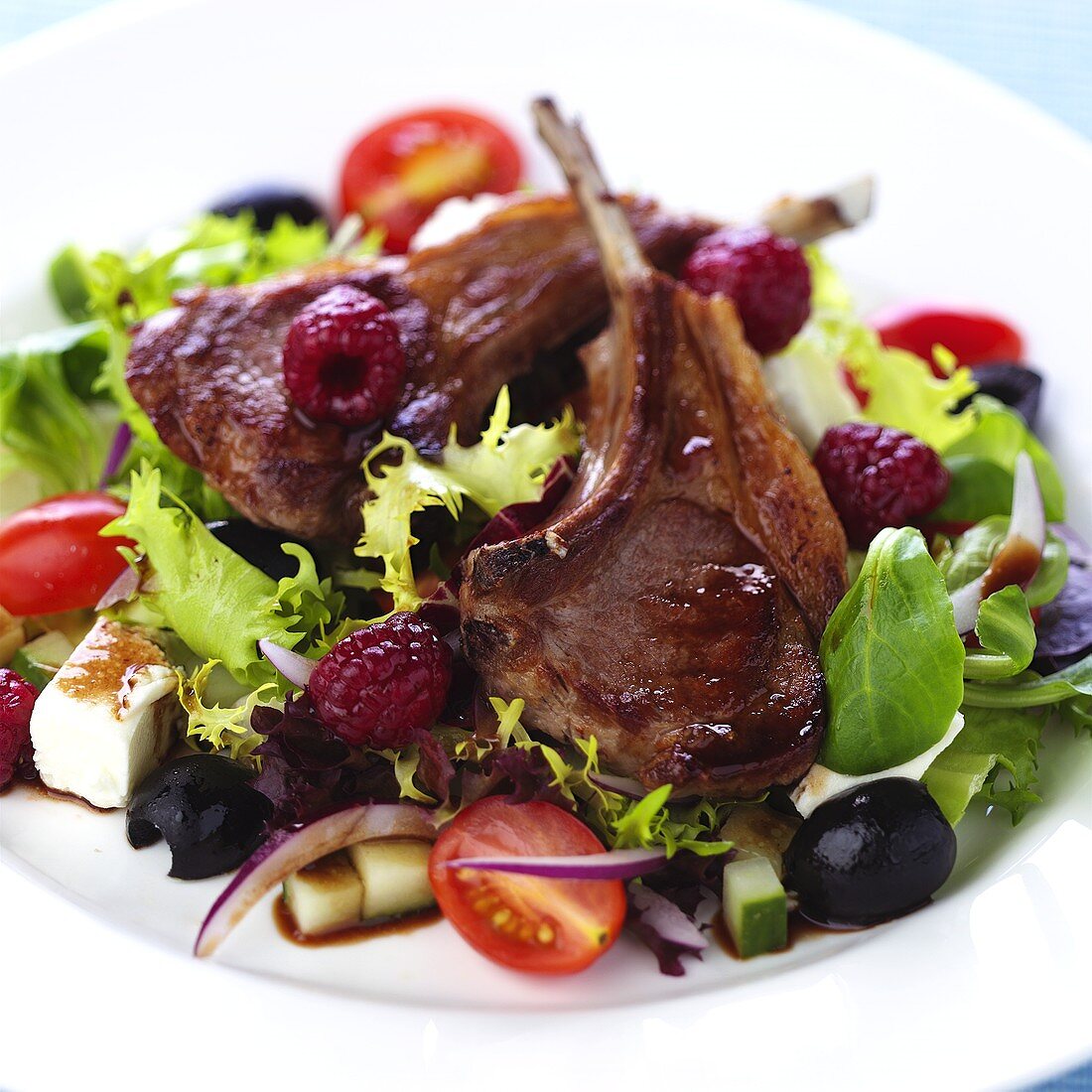 Lamb chops with raspberries on Greek salad