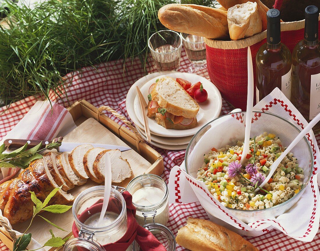 Picnic with roast turkey, pasta salad, white bread sandwich