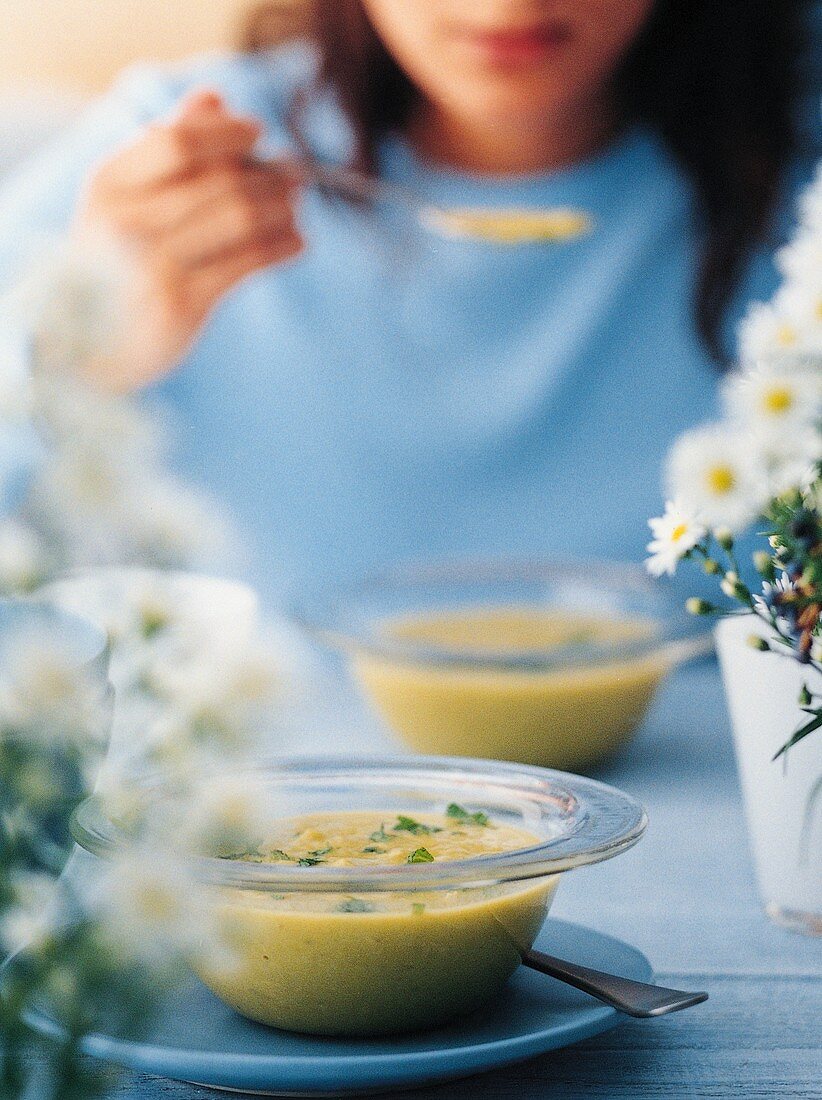 Junge Frau isst Kartoffelsuppe