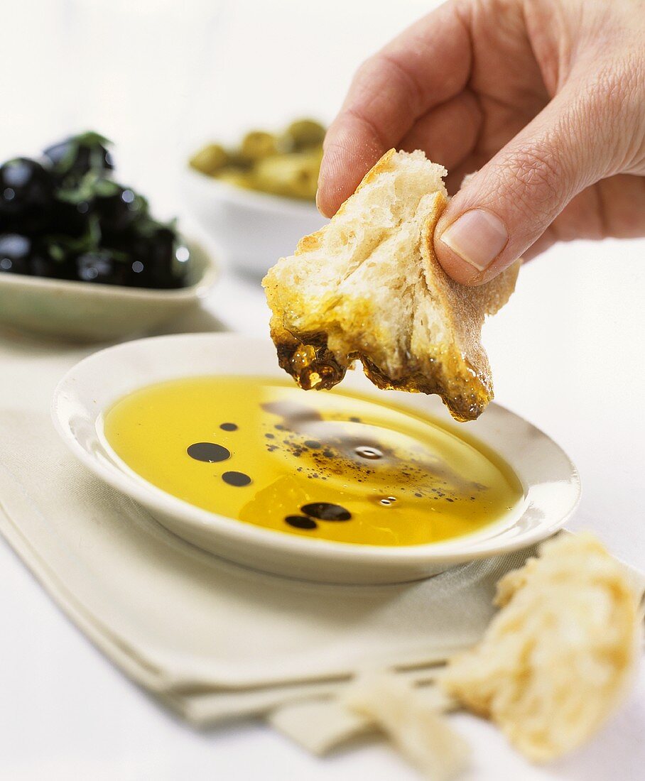 Dipping white bread in olive oil