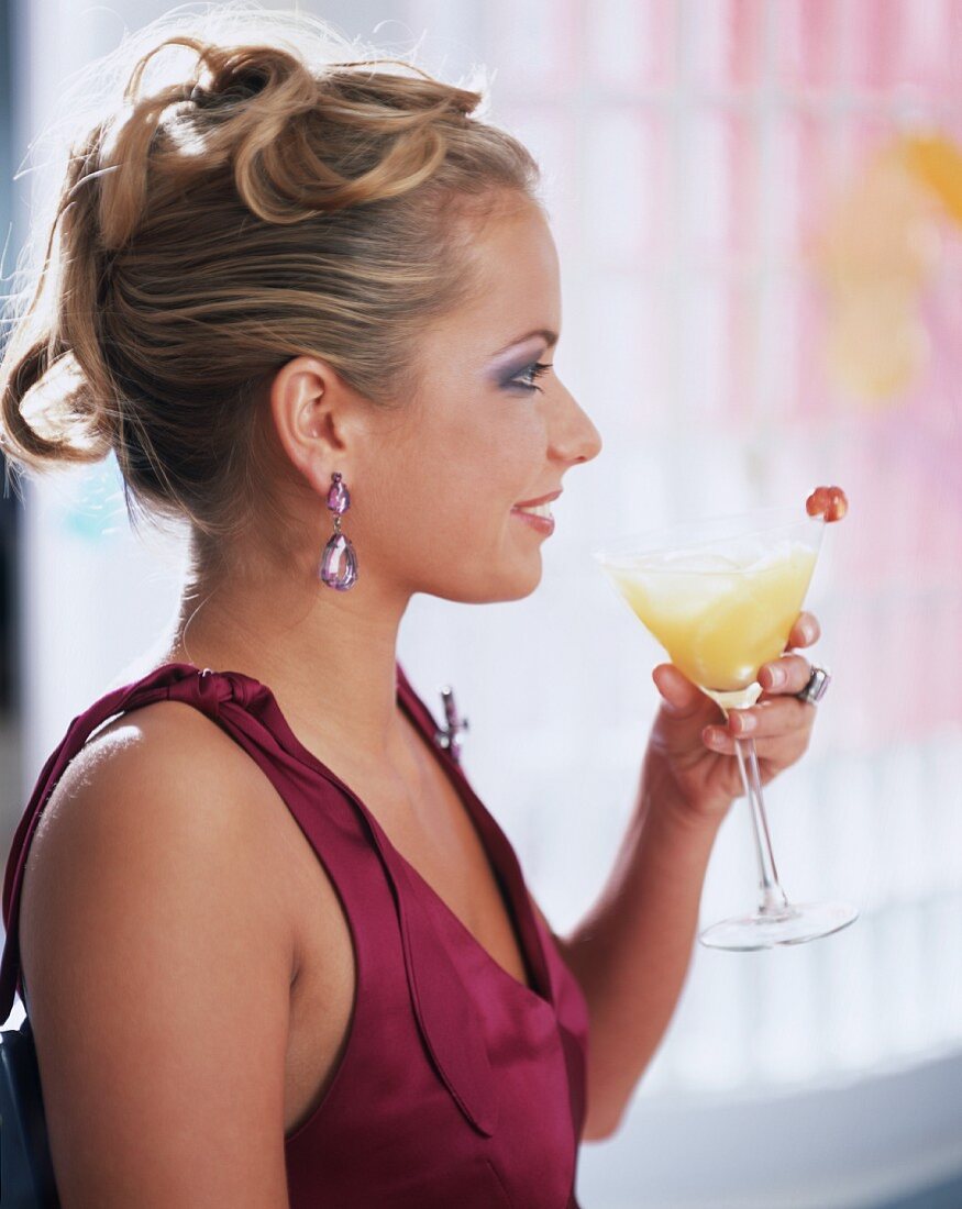Young woman holding glass of champagne and orange