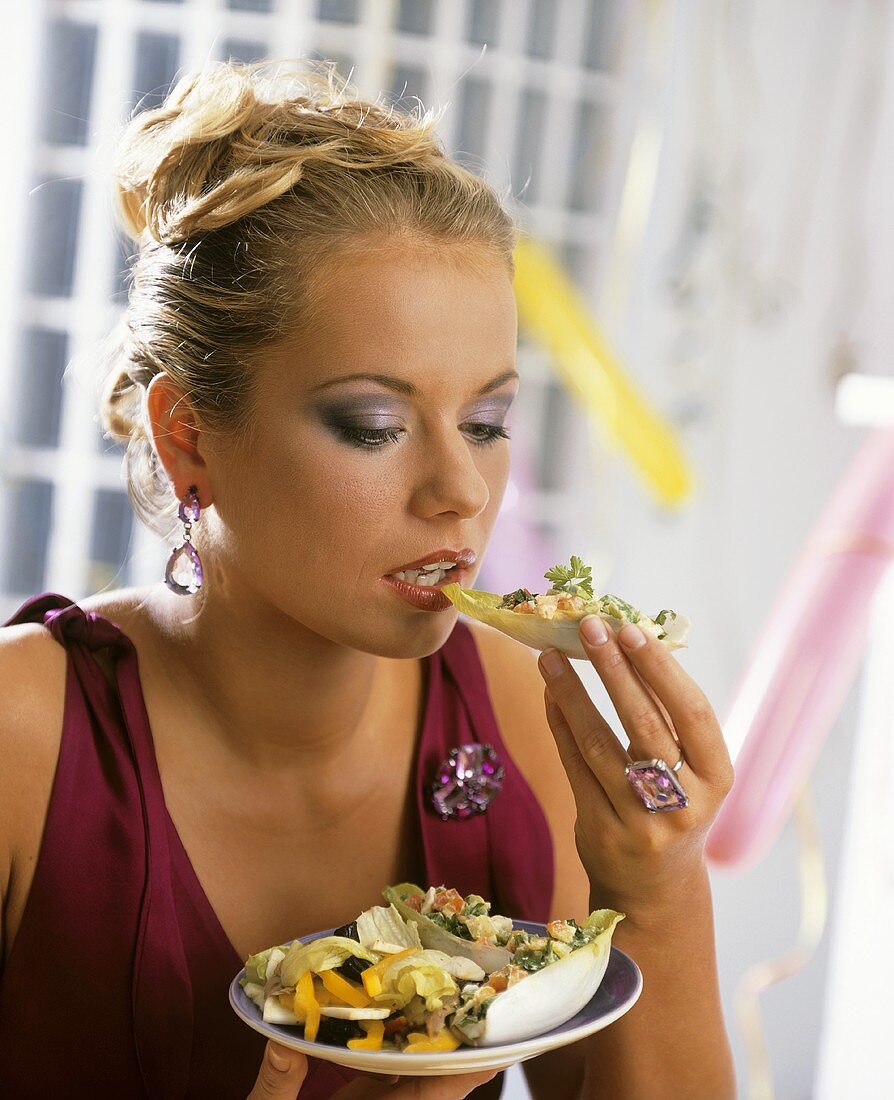 Young woman eating chicory snack