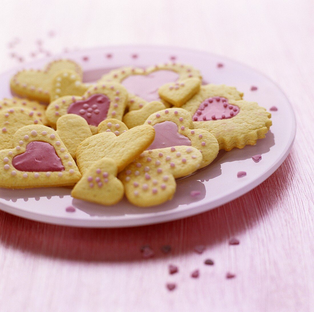 Herzförmige Plätzchen mit rosa Glasur und Zuckerperlen