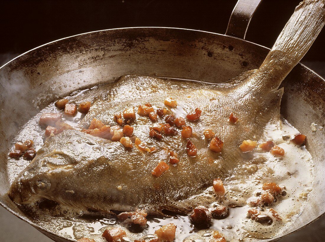 Whole Plaice with diced Bacon in a Frying Pan