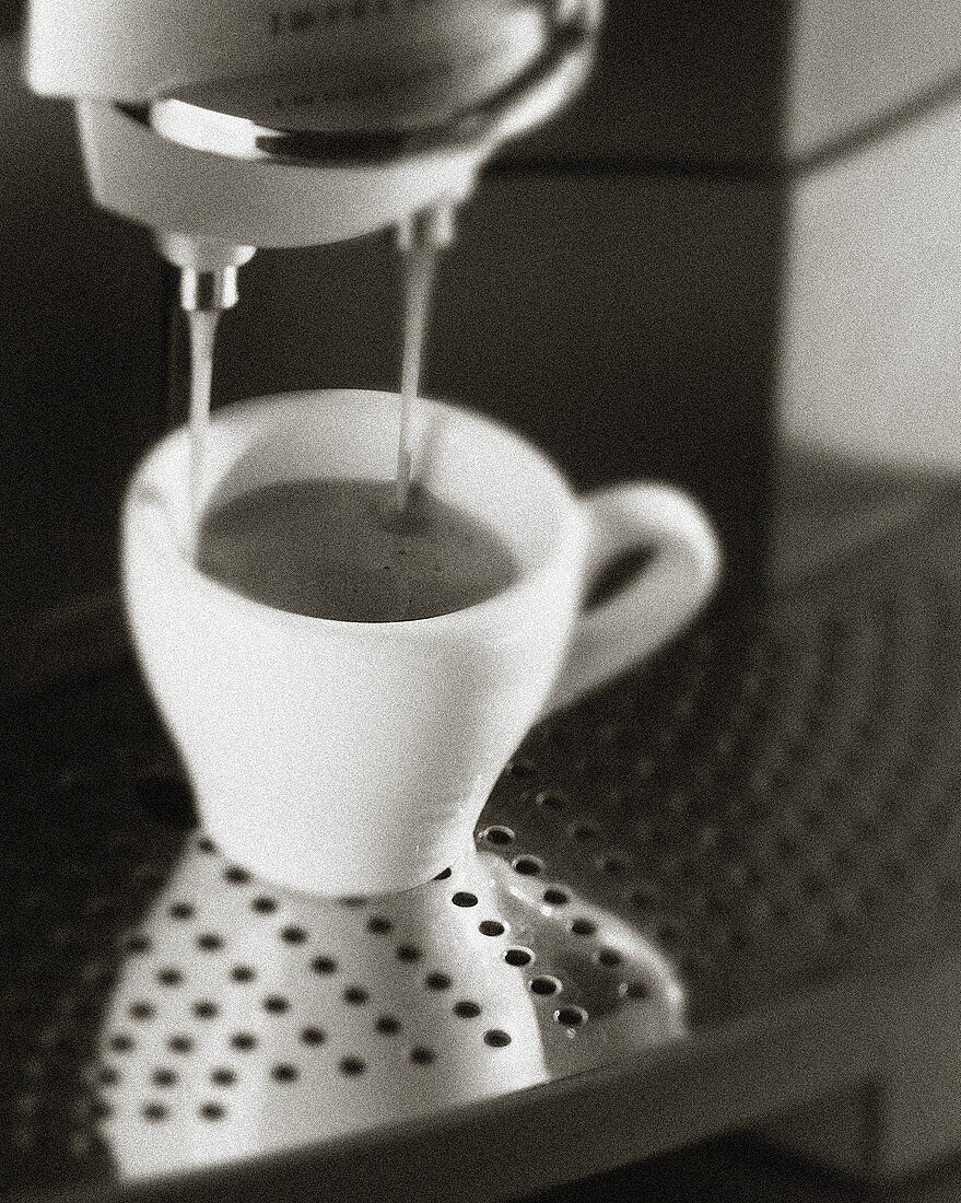 Espresso fliesst aus Espressomaschine (s-w-Aufnahme)