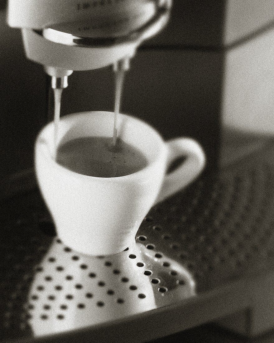 Espresso running out of espresso machine (b/w photo)