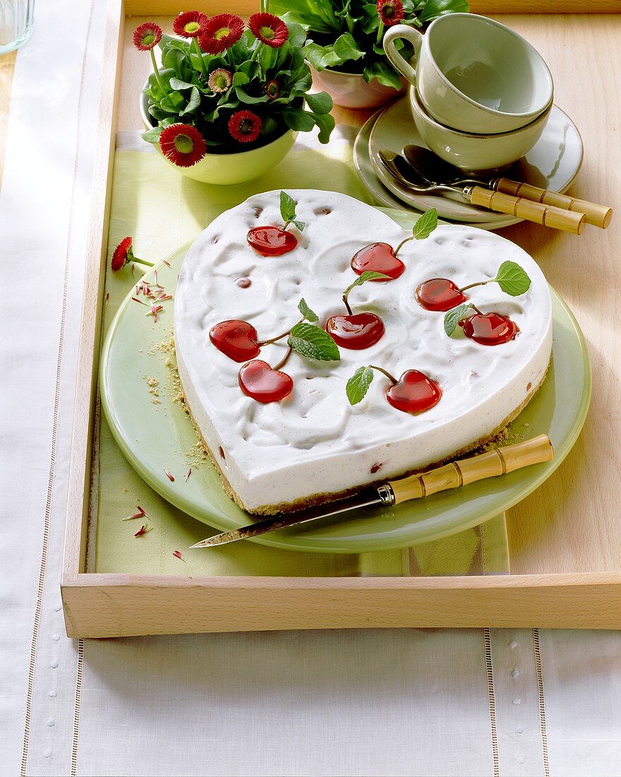 Herzförmige Joghurt-Kirsch-Torte, verziert mit Geleekirschen