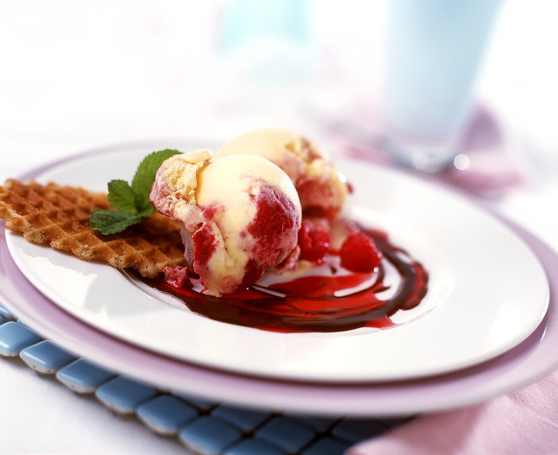 Vanilla and raspberry ice cream with wafers and raspberry sauce