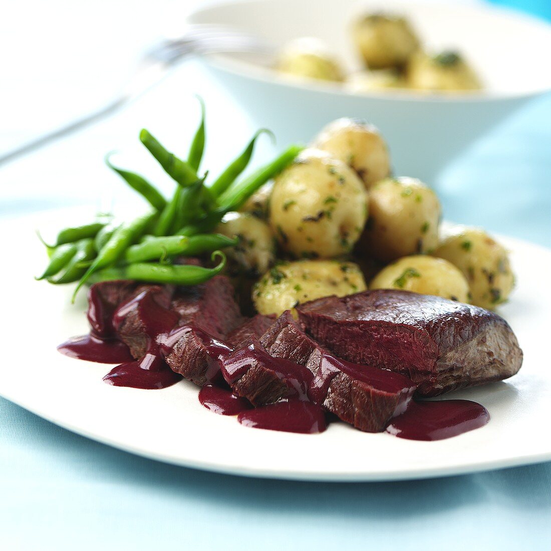 Venison fillet with red wine sauce, potatoes and beans