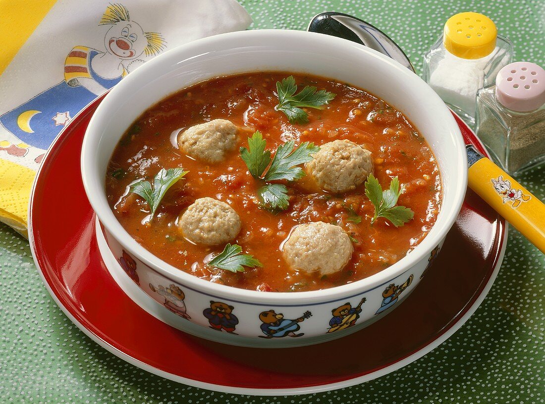 Tomatensuppe mit Wurstklösschen, serviert im Kinderteller