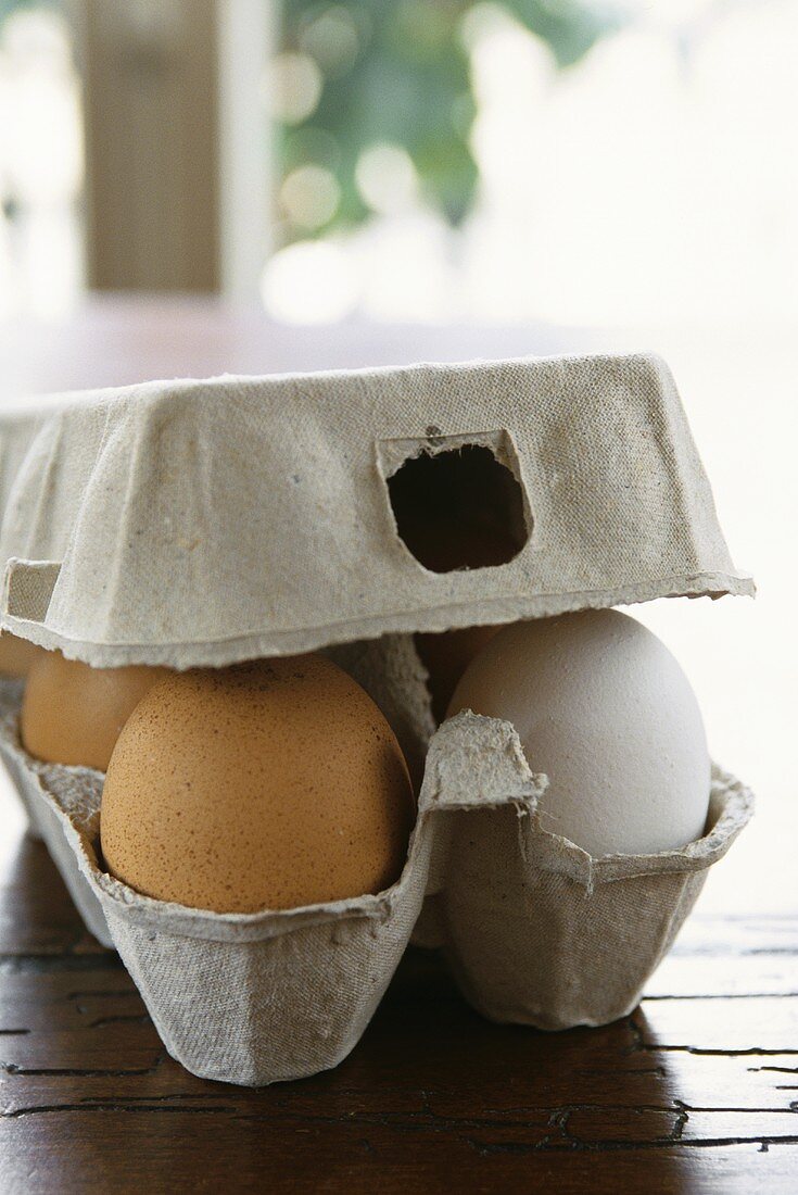White and brown eggs in box