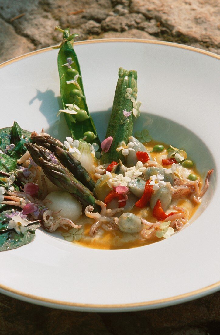 Seafood soup with spring vegetables and flowers