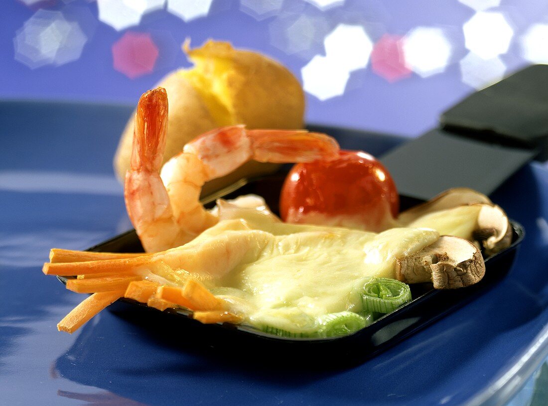 Raclette pan with vegetables, shrimps, cheese