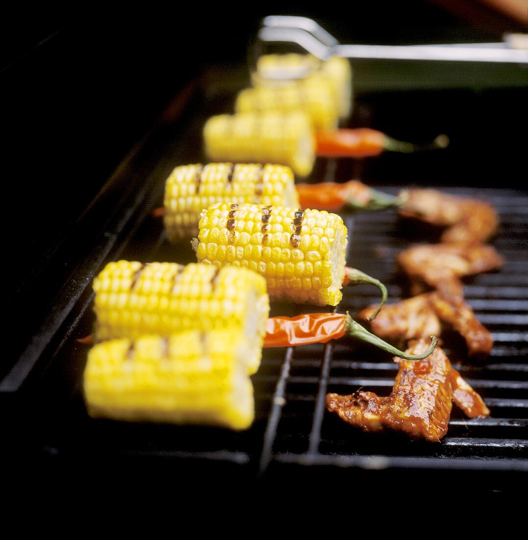 Corncobs and chicken wings on the barbecue