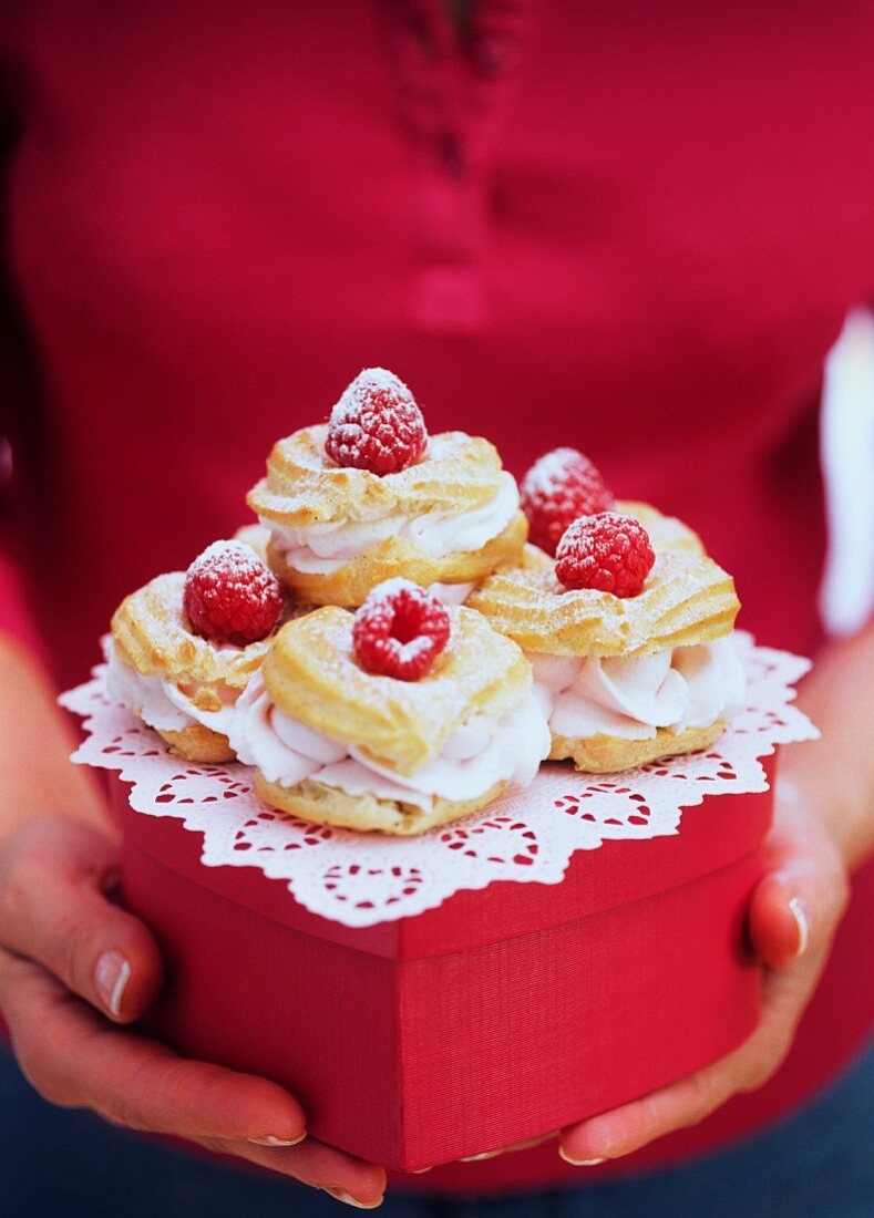 Profiteroles with raspberry cream on gift box