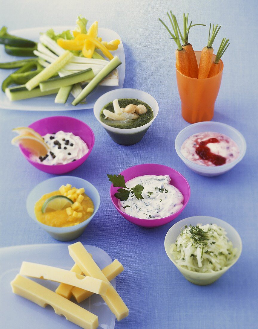 Six different dips; strips of cheese and raw vegetables