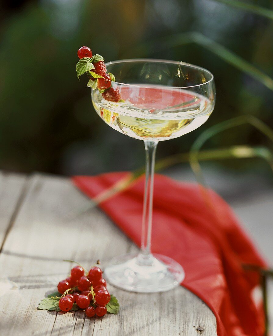 Champagne in champagne goblet with berries on cocktail stick