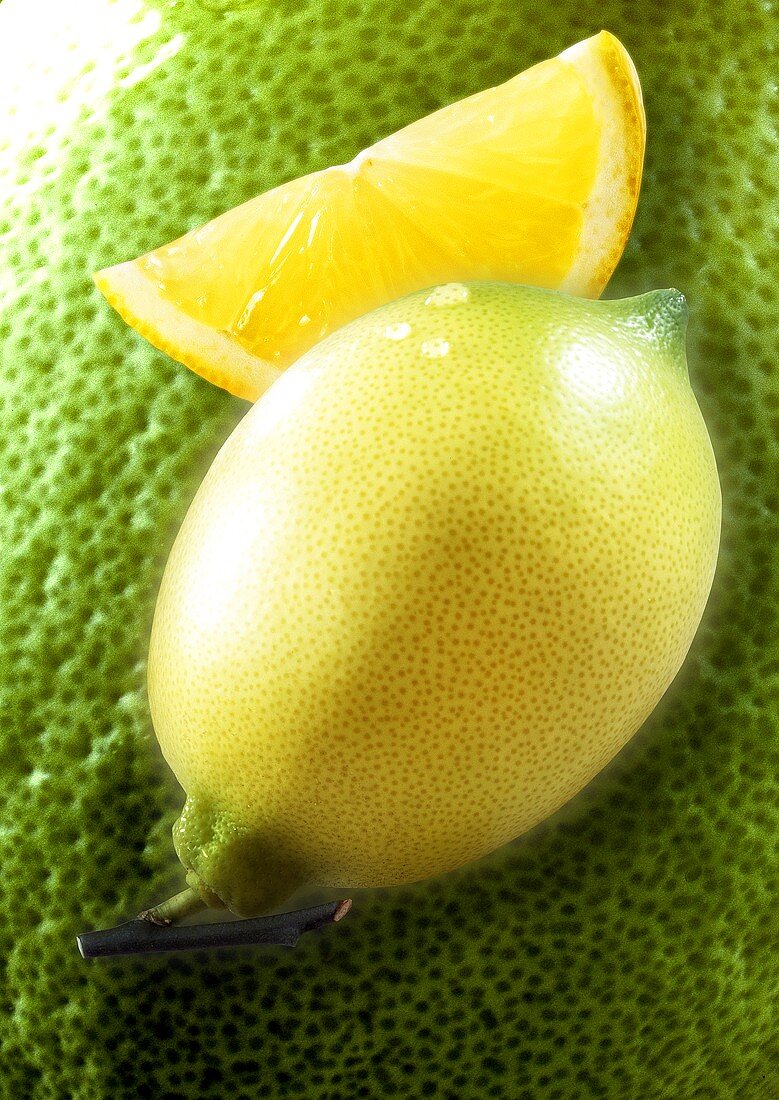 Lemon and lemon wedge, background: enlarged lemon