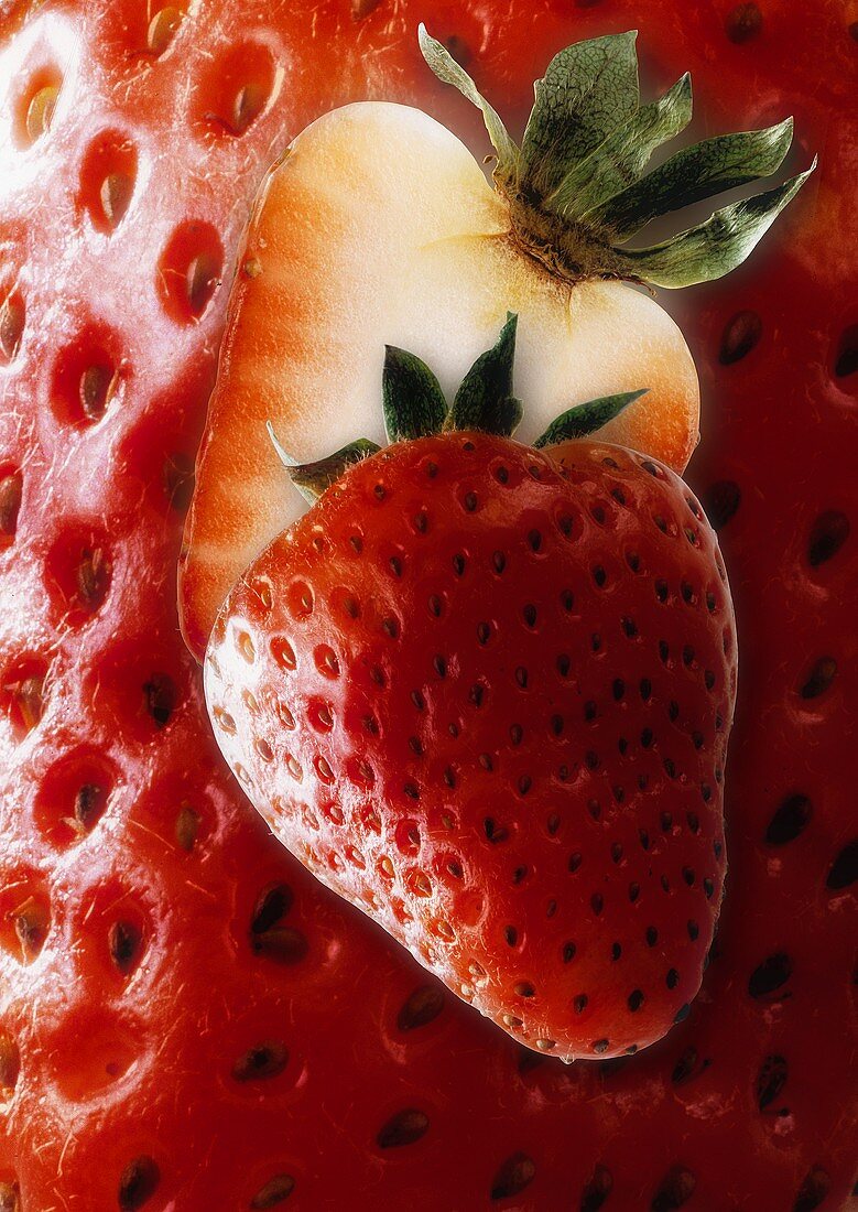 Halved strawberry, background: enlarged strawberry