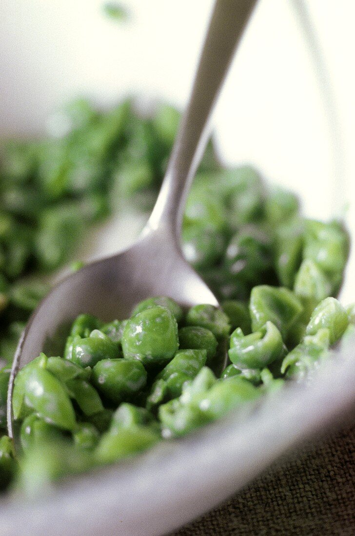 Peas with a spoon in a bowl