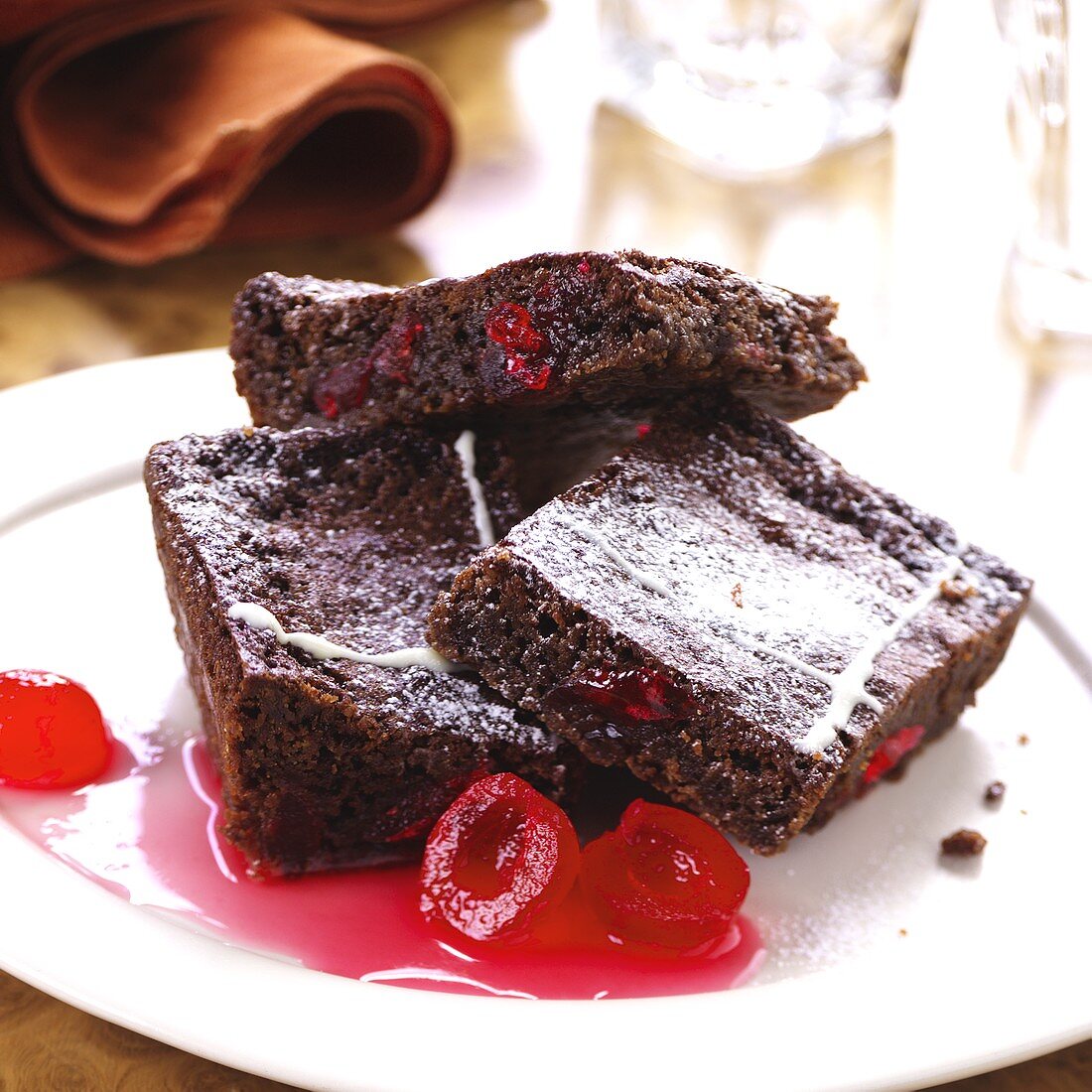 Three pieces of chocolate cake with glace cherries