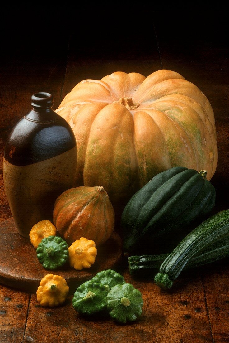 Still life with pumpkins, courgettes and pumpkin seed oil