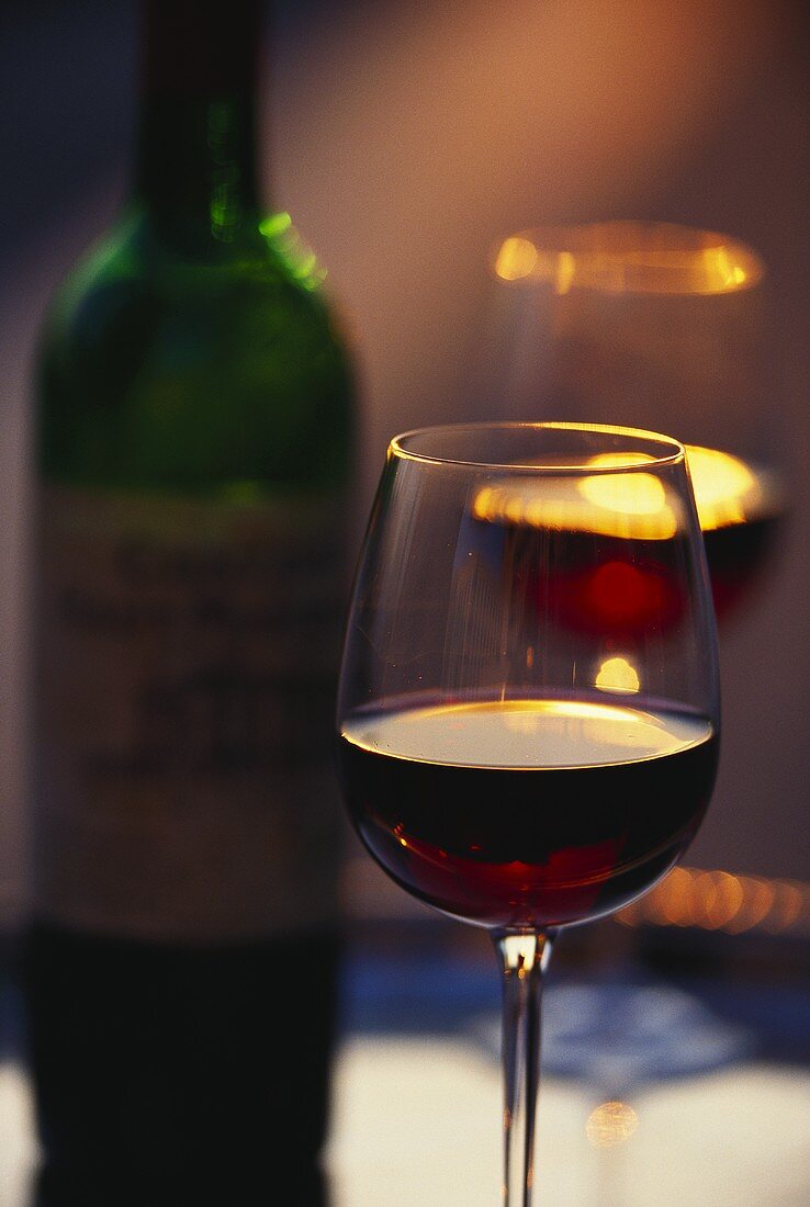 Rotweinstilleben mit Flasche und gefüllten Gläsern