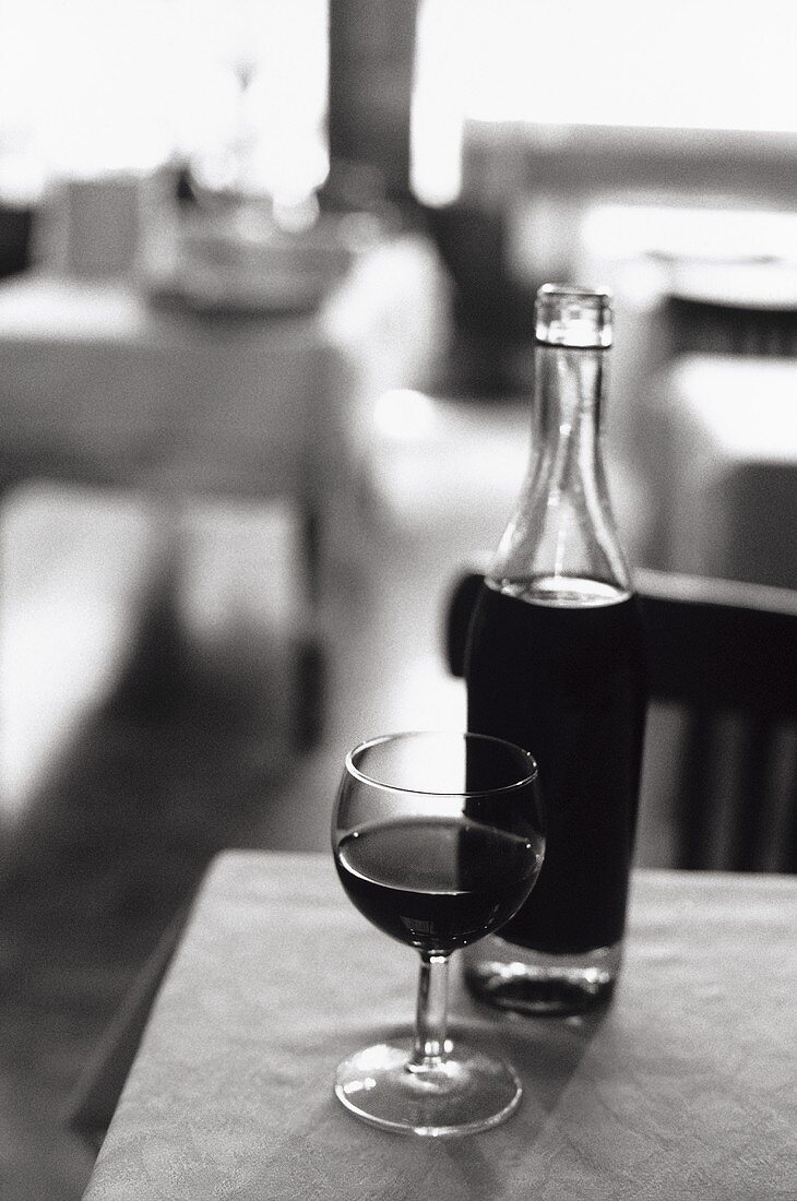 Pot Lyonnais (typische Lyoner Weinflasche) mit Glas in Bistro